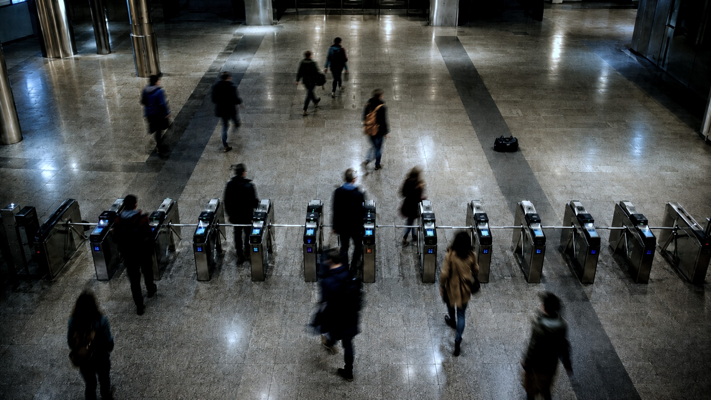 Station concourse and ticket gates seen from a ceiling camera
